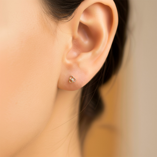 Oreja de modelo usando un topito en forma de flor calada en 3 oros de 18 quilates de Joyería Caracas.