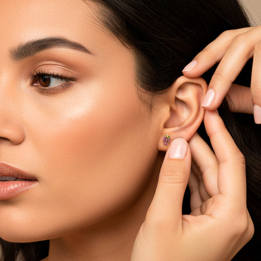 Oreja de modelo usando un topito en forma de fresa en oro amarillo de 18 quilates y cristales de Joyería Caracas.