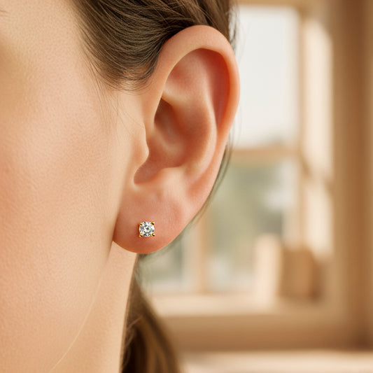 Oreja de modelo usando un topito en oro amarillo de 18 quilates con cristal de color blanco de Joyería Caracas.