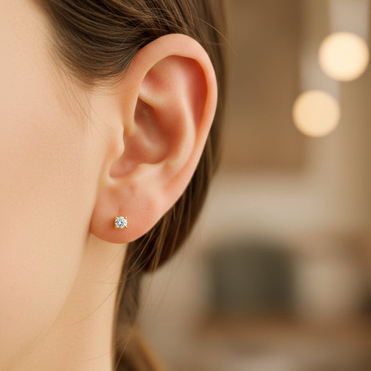 Oreja de modelo usando un topito en oro amarillo de 18 quilates con Diamante de color blanco de Joyería Caracas.