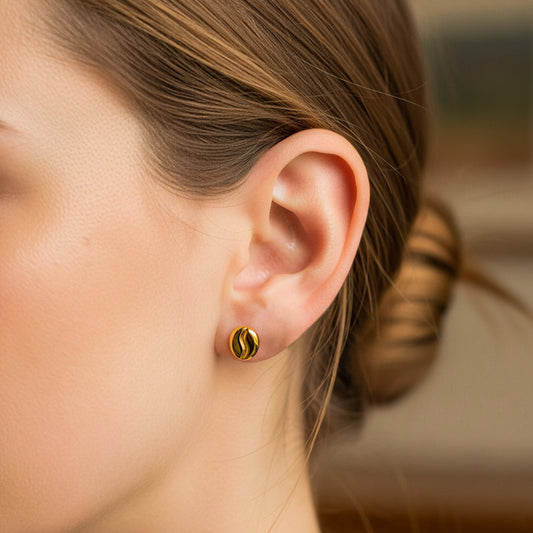 Oreja de modelo usando un topito en forma de grano de café en oro amarillo de 18 quilates de Joyería Caracas.