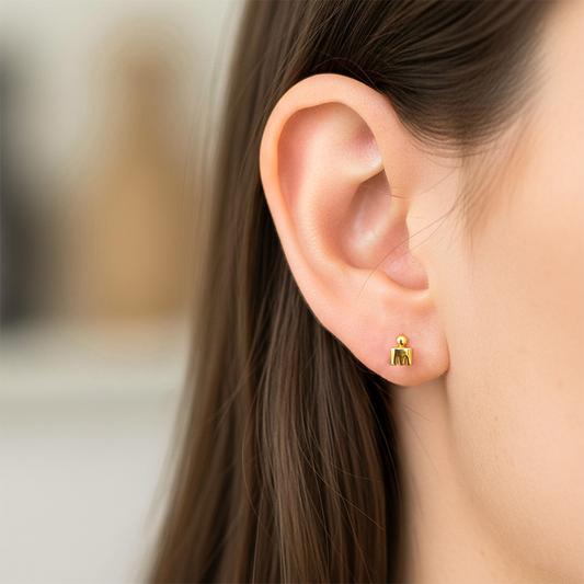 Oreja de modelo usando un topito con el logotipo de la competencia Ironman en oro amarillo de 18 quilates de Joyería Caracas.