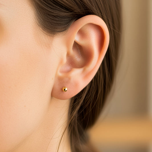 Oreja de modelo usando un topito de media esfera diamantada en oro amarillo de 18 quilates de Joyería Caracas.