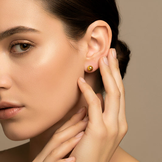 Oreja de modelo usando un topito de media esfera diamantada 6.0mm en oro amarillo de 18 quilates de Joyería Caracas.