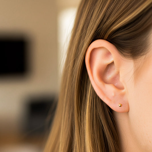 Oreja de modelo usando un topito de media esfera de 2,5mm en oro amarillo de 18 quilates de Joyería Caracas.