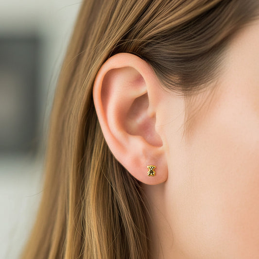 Oreja de modelo usando un topito en forma de oso en oro amarillo de 18 quilates de Joyería Caracas.