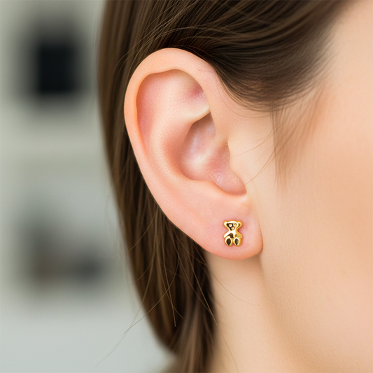 Oreja de modelo usando un topito en forma de oso en oro amarillo de 18 quilates de Joyería Caracas.