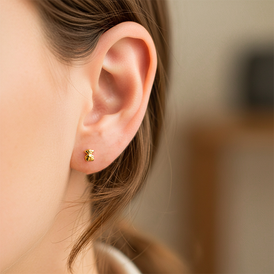 Oreja de modelo usando un topito en forma de oso en oro amarillo de 18 quilates de Joyería Caracas.