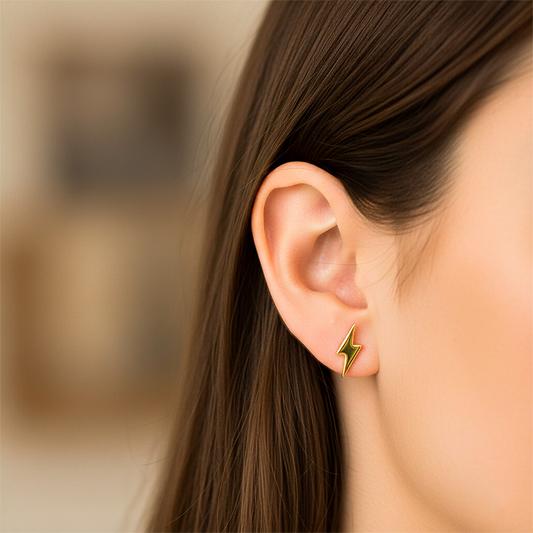 Oreja de modelo usando un topito en forma de rayo en oro amarillo de 18 quilates de Joyería Caracas.