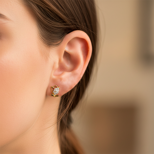 Oreja de modelo usando un topito en forma de flor en oro amarillo de 18 quilates con cristales de color blanco de Joyería Caracas.
