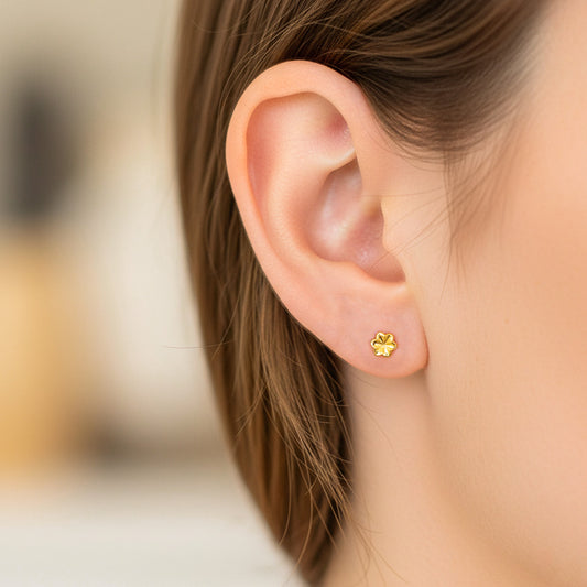 Oreja de modelo usando un topito en forma de rosa intercalada en oro amarillo de 18 quilates de Joyería Caracas.