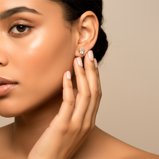 Oreja de modelo usando un topito en forma de corazón en oro amarillo de 18 quilates con cristal en forma de corazón de Joyería Caracas.