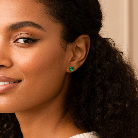 Oreja de modelo usando un topito cuadrado en oro amarillo de 18 quilates con Esmeralda de color verde de Joyería Caracas.
