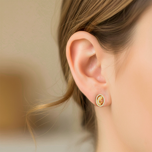 Oreja de modelo usando un topito de la Virgen María en oro amarillo de 18 quilates con cristales de Joyería Caracas.