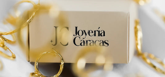 Muchas Candongas de oro regadas alrededor de una caja de Joyería Caracas
