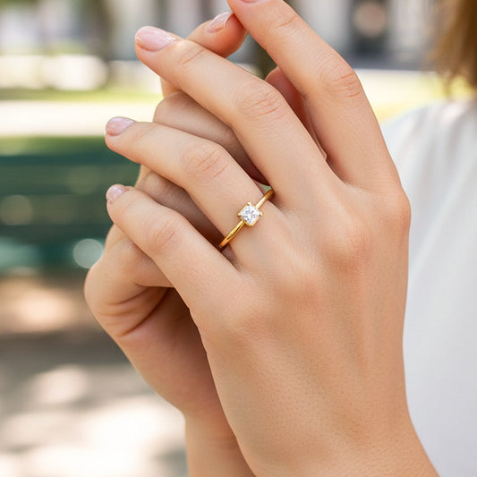 Mano de una modelo usando un anillo en oro amarillo con cristal de Joyería Caracas.