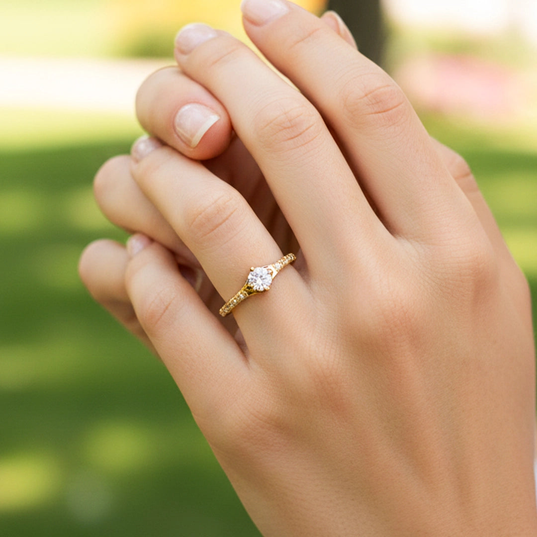 Mano de una modelo usando un anillo en oro amarillo con cristal de Joyería Caracas.