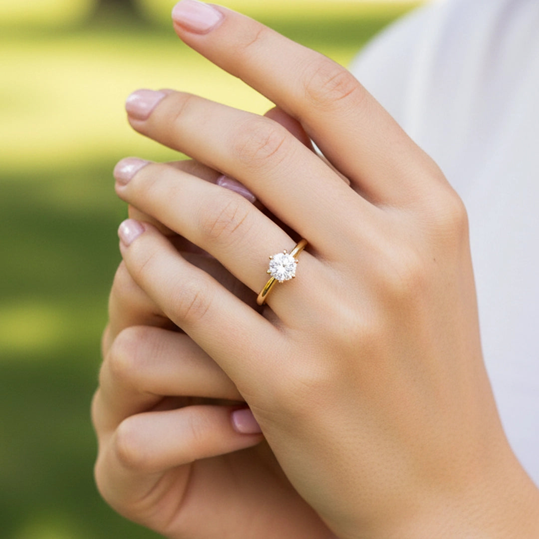 Mano de una modelo usando un anillo en oro amarillo con cristal de Joyería Caracas.