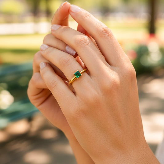 Mano de una modelo usando un anillo en oro amarillo con Esmeralda Colombiana de Joyería Caracas.