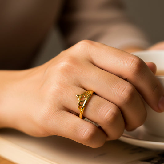 Mano de mujer usando un anillo con forma de corona en oro amarillo de 18 quilates de Joyería Caracas. 