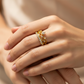 Mano de mujer usando un anillo con forma de corazón en oro amarillo de 18 quilates con cristales de color blanco de Joyería Caracas. 