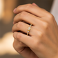 Mano de mujer usando un anillo con forma de corazón en el centro con cristales de color blanco de Joyería Caracas. 
