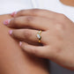Mano de mujer con anillo pisargolla en oro amarillo de 18 quilates con cristal en un lateral de color blanco y cristales en forma de trapecios de color blanco de Joyería Caracas.