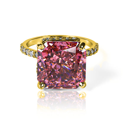 Anillo Zafiro Padparadscha sintético, este anillo presenta un zafiro sintético, reconocido por su tonalidad única que combina matices rosados y anaranjados, acompañado de moissanitas que realzan su brillo. Elaborado en oro de 18k.