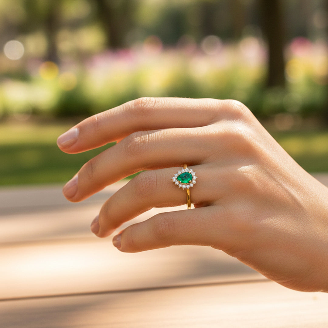 Mano de modelo usando un anillo en oro amarillo de 18 quilates con Esmeralda en forma de gota y cristales de Joyería Caracas. 