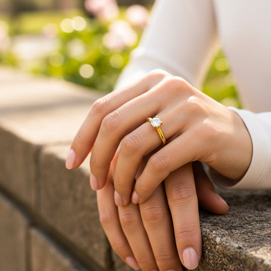 Mano de modelo usando un anillo clásico en oro amarillo de 18 quilates con cristal de Joyería Caracas. 