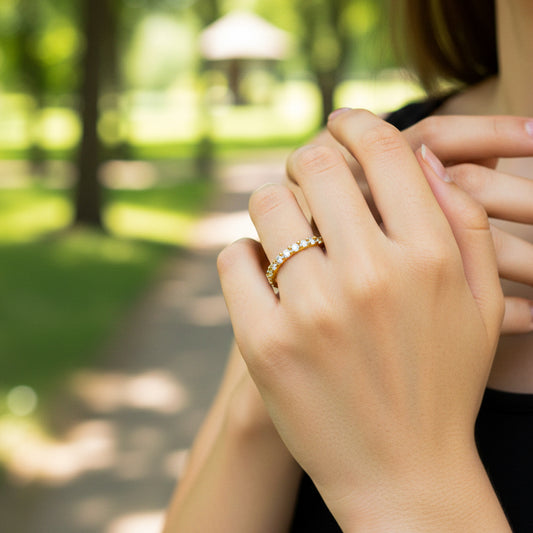 Mano de modelo usando un anillo sin fin en oro amarillo de 18 quilates con cristales de Joyería Caracas. 