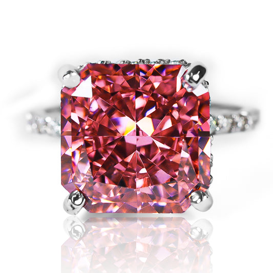 Anillo Zafiro Padparadscha sintético, este anillo presenta un zafiro sintético, reconocido por su tonalidad única que combina matices rosados y anaranjados, acompañado de moissanitas que realzan su brillo. Elaborado en oro de 18k.
