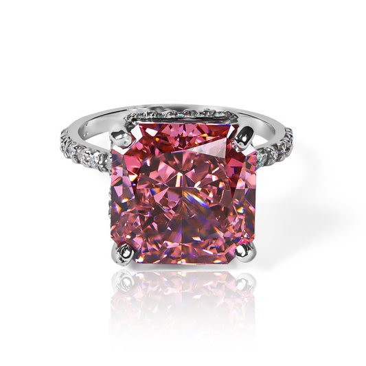 Anillo Zafiro Padparadscha sintético, este anillo presenta un zafiro sintético, reconocido por su tonalidad única que combina matices rosados y anaranjados, acompañado de moissanitas que realzan su brillo. Elaborado en oro de 18k.