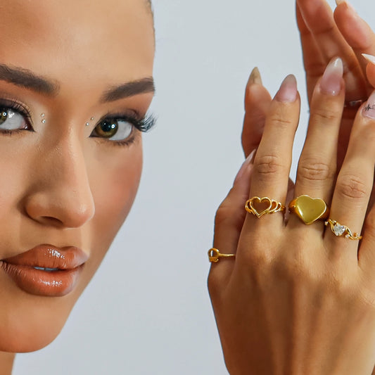 Mano de mujer con anillo en forma de corazón calado en oro amarillo de 18 quilates, hecho en Joyería Caracas. 