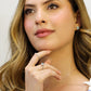 Mano de mujer usando un anillo en oro blanco de 18 quilates con cristales de color blanco alrededor de Joyería Caracas.