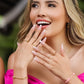 Mano de mujer con anillo de 3 líneas con un corazón en cada una en oro amarillo de 18 quilates y cristales de color de distintos colores y blanco, hecho en Joyería Caracas. 
