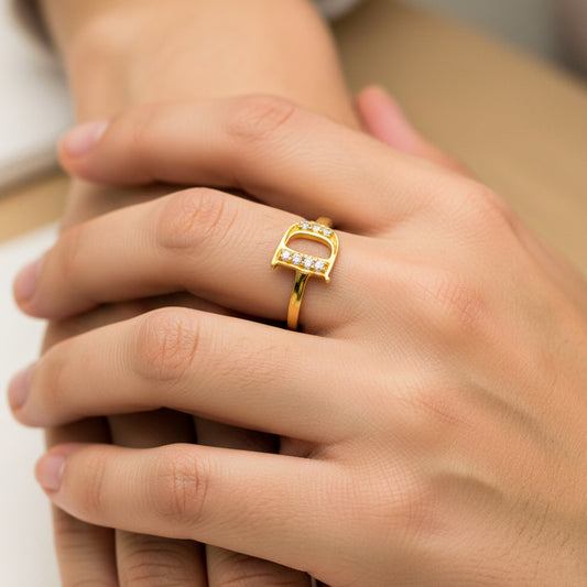 Mano de mujer usando un anillo en oro amarillo de 18 quilates con la letra D en el centro con cristales de color blanco de Joyería Caracas. 