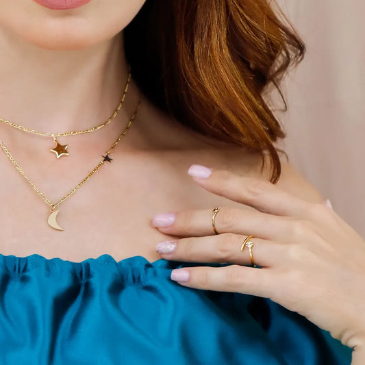Mano de mujer usando un anillo con forma de trébol en la punta en oro amarillo de 18 quilates, fabricado en Joyería Caracas. 