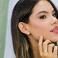 Oreja de mujer usando un arete inspirado en las palmeras de Miami en oro amarillo de 18 quilates de Joyería Caracas.