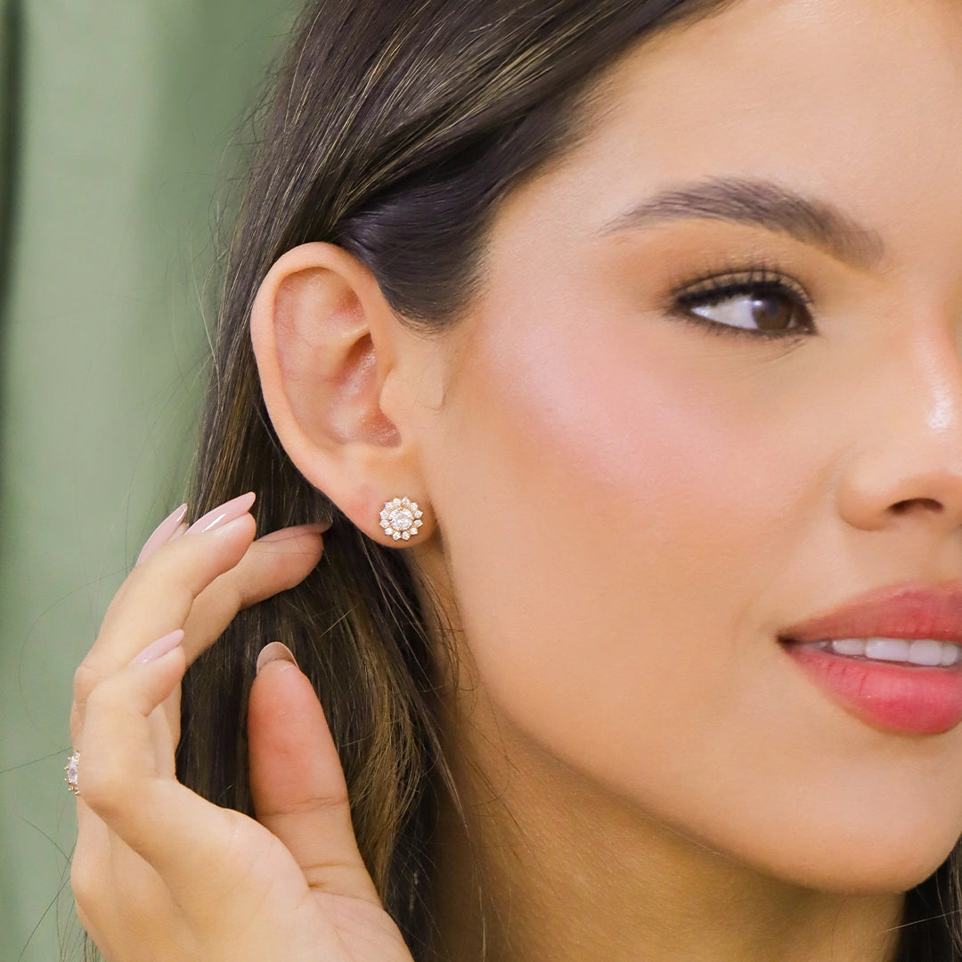 Oreja de mujer usando un arete inspirado en las palmeras de Miami en oro amarillo de 18 quilates de Joyería Caracas.