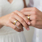 Manos de una pareja usando unas argollas en oro amarillo y blanco de 18 quilates de Joyería Caracas.