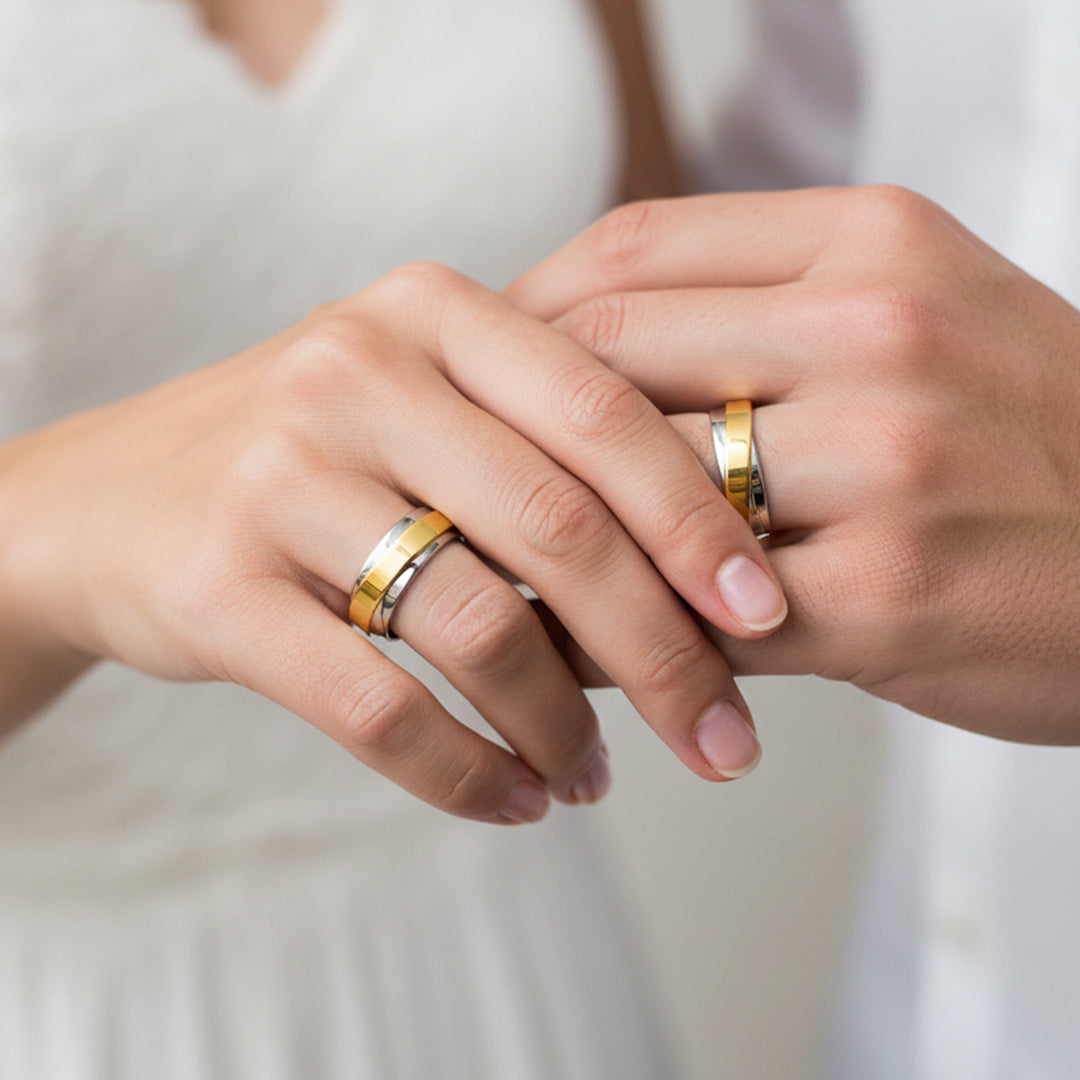 Manos de una pareja usando unas argollas en oro amarillo y blanco de 18 quilates de Joyería Caracas.