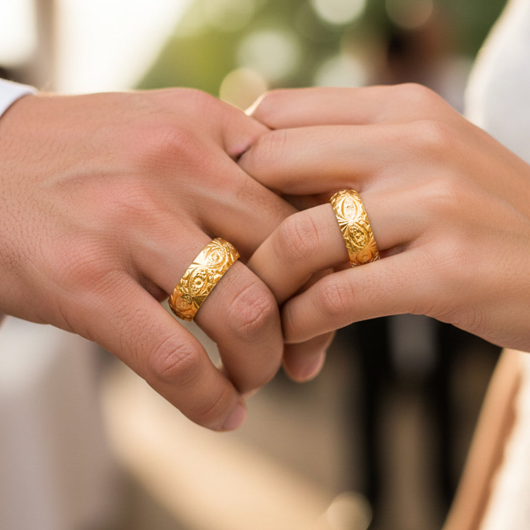 Manos de una pareja usando unas argollas en oro amarillo de 18 quilates de Joyería Caracas. 