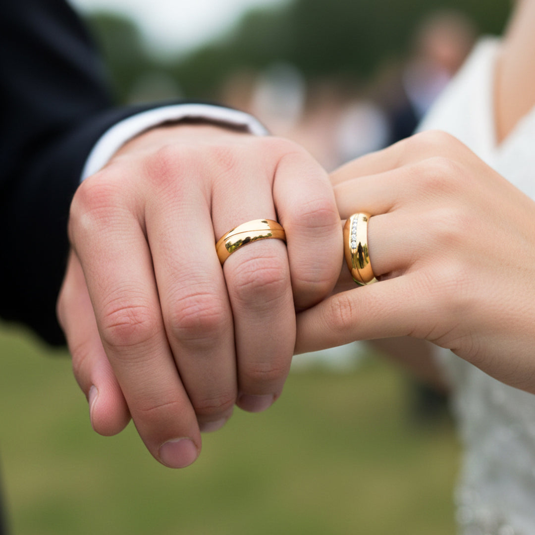 Manos de una pareja usando unas argollas en oro amarillo de 18 quilates de Joyería Caracas. 