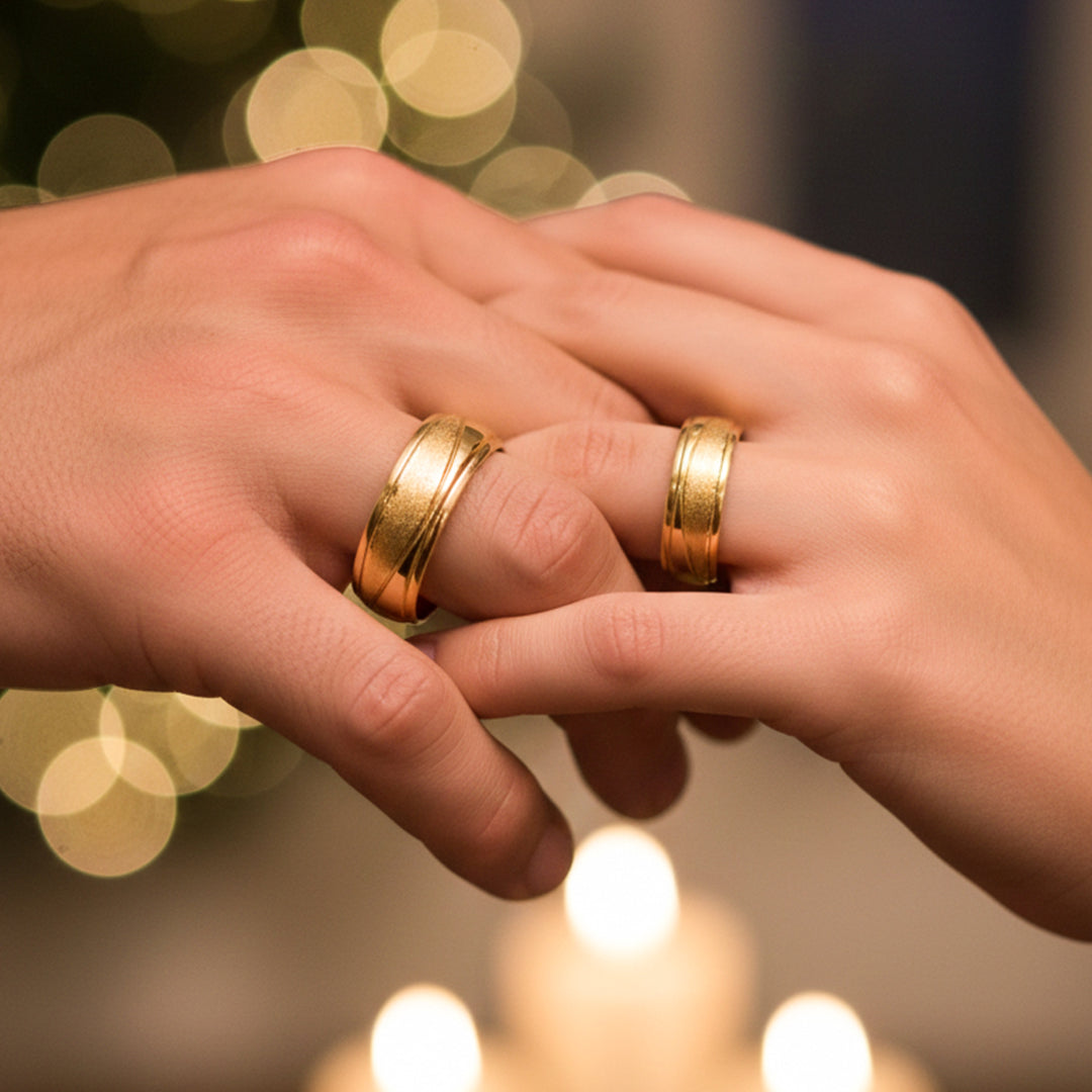 Manos de una pareja usando unas argollas en oro amarillo de 18 quilates de Joyería Caracas.