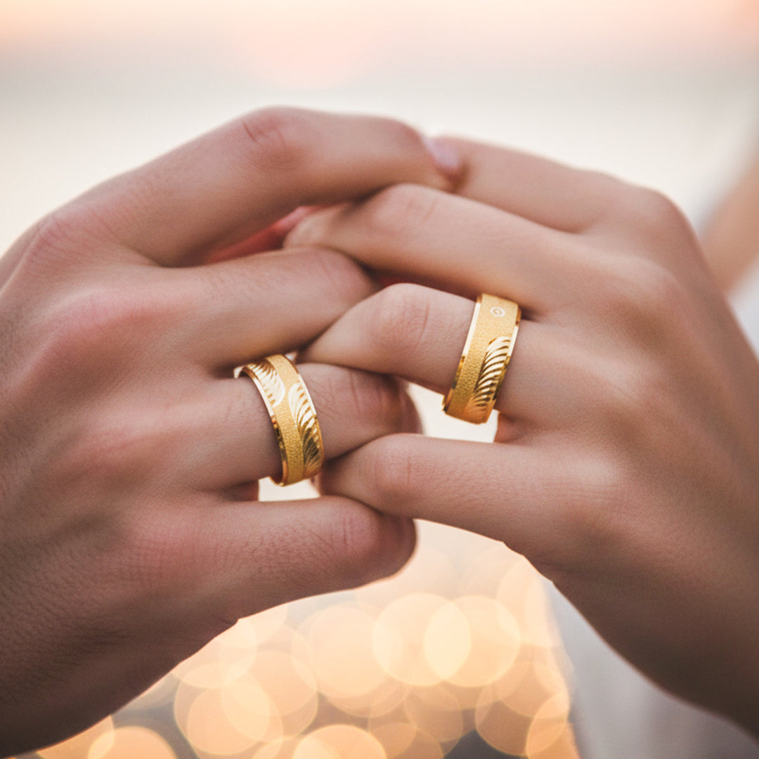 Manos de una pareja usando unas argollas en oro amarillo de 18 quilates de Joyería Caracas.