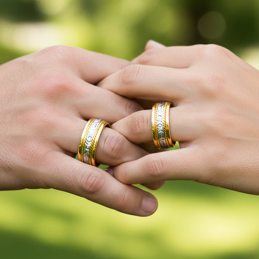 Manos de una pareja usando unas argollas de matrimonio en oro amarillo y blanco de 18 quilates de Joyería Caracas. 