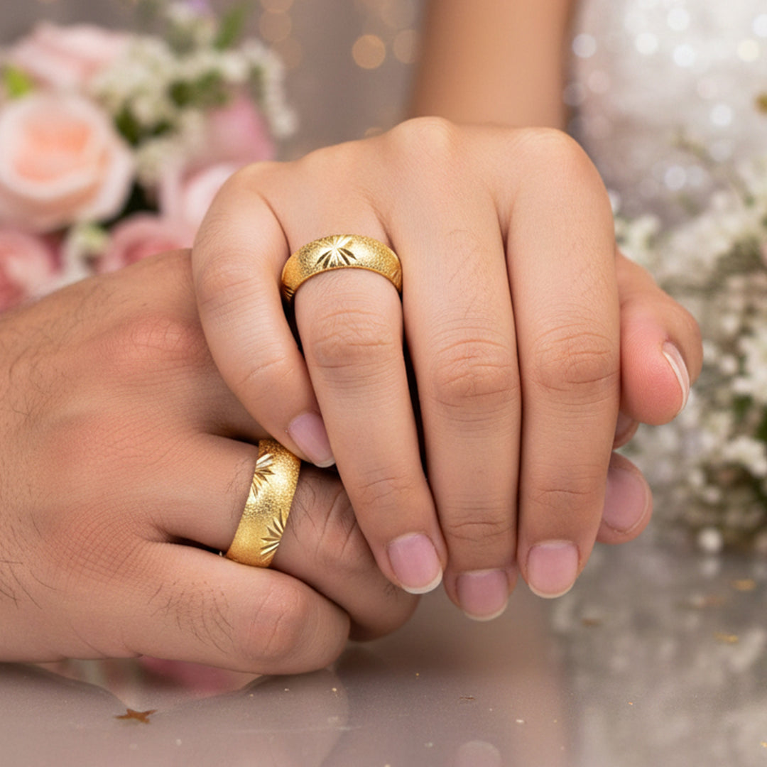 Manos de una pareja usando unas argollas en oro amarillo de 18 quilates de Joyería Caracas. 