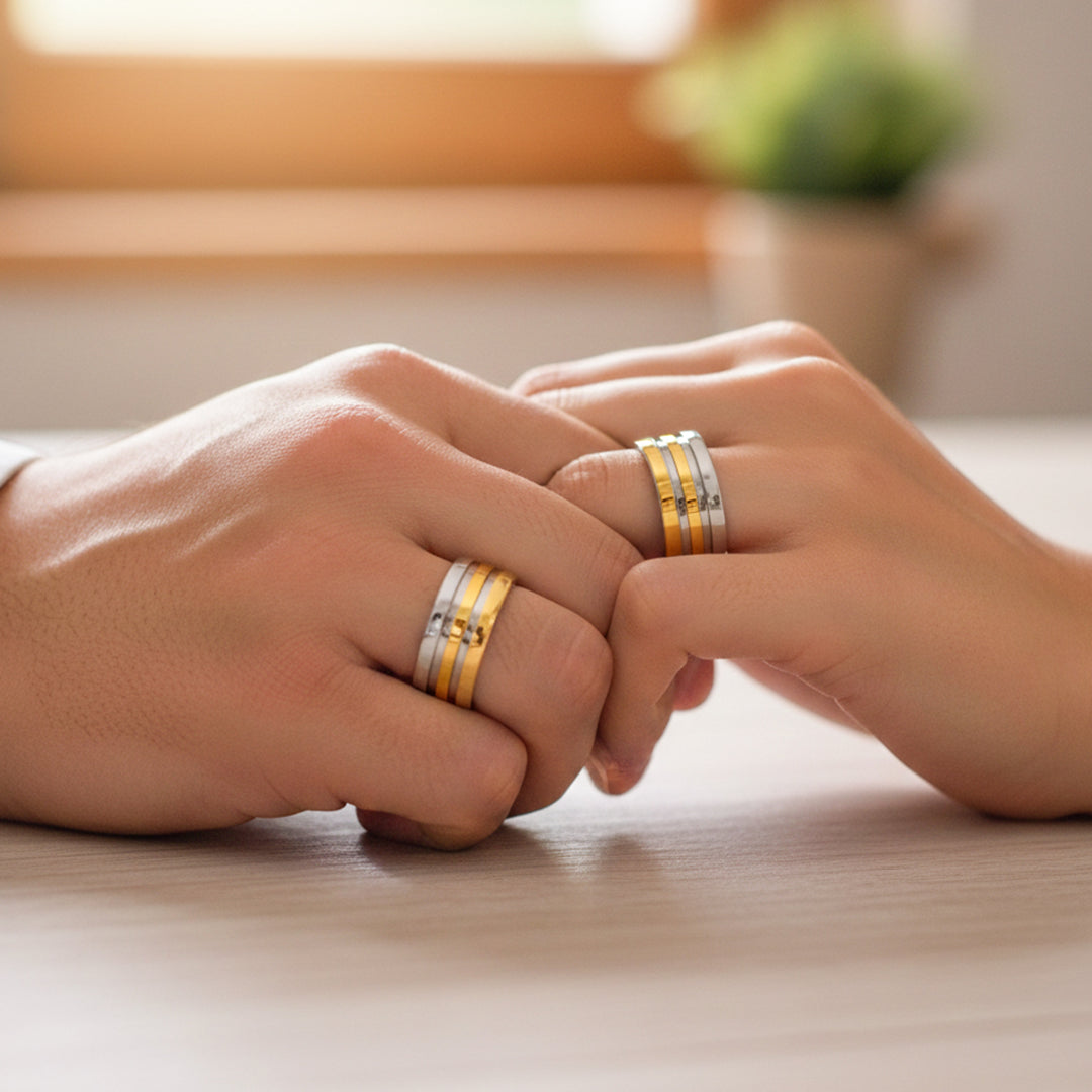 Mano de pareja usando unas argollas de matrimonio en oro amarillo y blanco de 18 quilates de Joyería Caracas. 