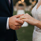 Manos de una pareja usando unas argollas de matrimonio en oro amarillo de 18 quilates de Joyería Caracas. 
